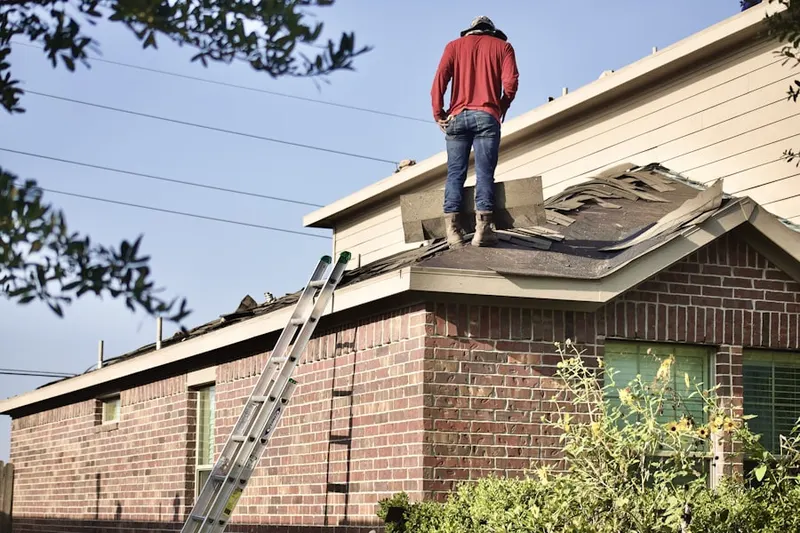 Professional roofer working on a residential roof in Aston Mills